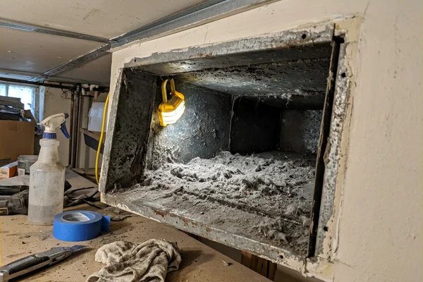 Dusty return air duct interior with debris buildup before cleaning