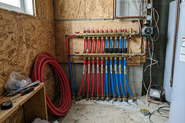 Hydronic in-floor heating manifold with PEX loops and flow meters