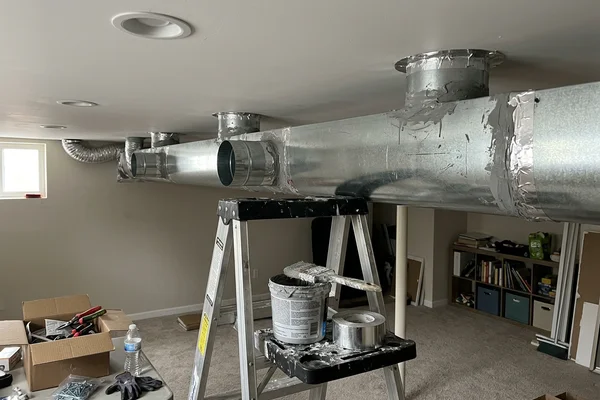 New sheet metal trunk duct with sealed joints in a finished basement ceiling