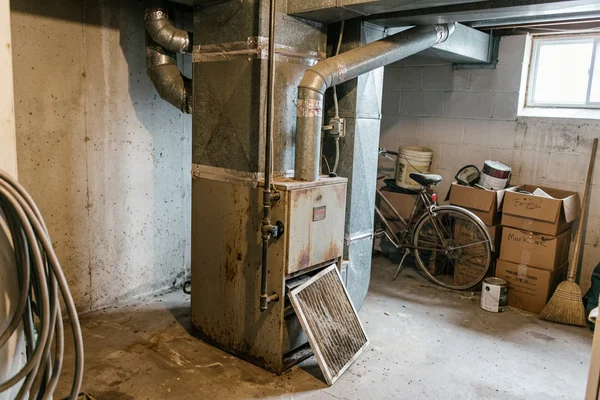 Old mid-efficiency furnace before replacement in a Toronto basement