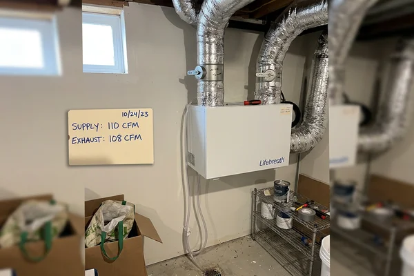 Wall-mounted heat recovery ventilator with insulated ducting and balanced flow dampers