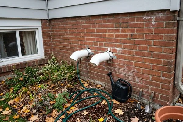 PVC intake and exhaust venting terminating through the side wall of a Toronto house